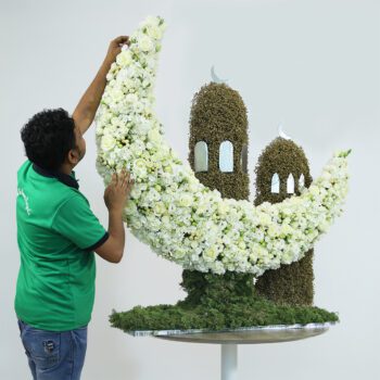 Elegant crescent Eid flowers with mosque design in fresh blooms.