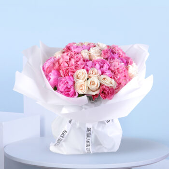 Pink and white floral bouquet wrapped in white with an "Eid Mubarak" topper.