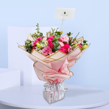 Pink bouquet with roses and pastel flowers, beautifully wrapped with a stylish ribbon for gifting.