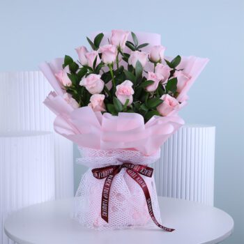 Bouquet of soft baby pink roses wrapped elegantly with ribbon.