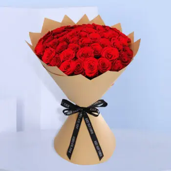 Large red roses are elegeantlly arranged in a big bouquet.