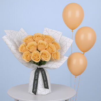 12 peach roses in patterned white wrap, paired with matching peach balloons.