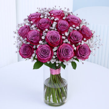 20 deep purple roses in a glass vase with baby’s breath