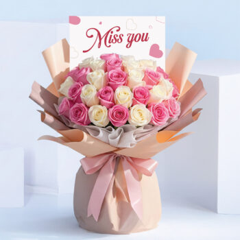 Bouquet featuring hand-tied pink roses & white roses in pastel wrap, finished with a “Miss You” card.