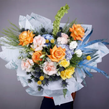 Bouquet featuring hand-tied roses, hydrangeas & exotic flowers in designer wrap, finished with lush greenery.