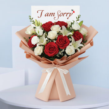 Bouquet featuring hand-tied red roses, white roses & lilies in peach wrap, finished with an “I am Sorry” card.