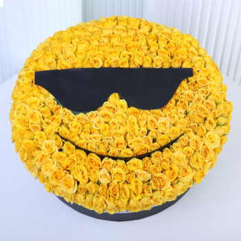 Yellow spray roses arranged in a cool sunglasses smiley-face floral box design.
