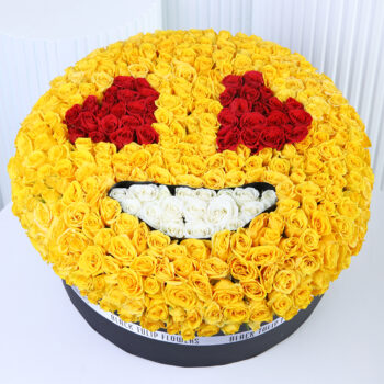 Yellow spray roses arranged in a smiley-face floral box design with red and white rose detailing.